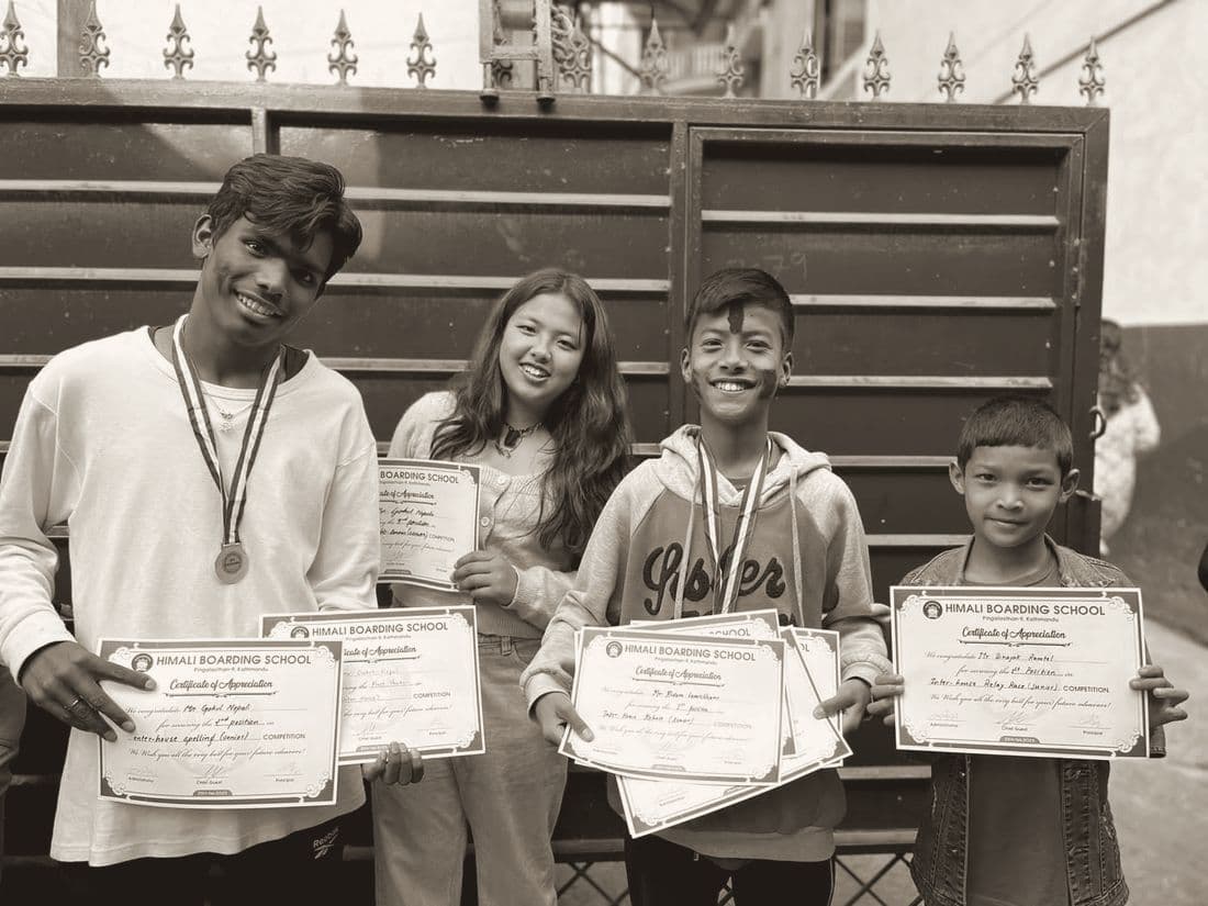 Students holding their certificates and medals