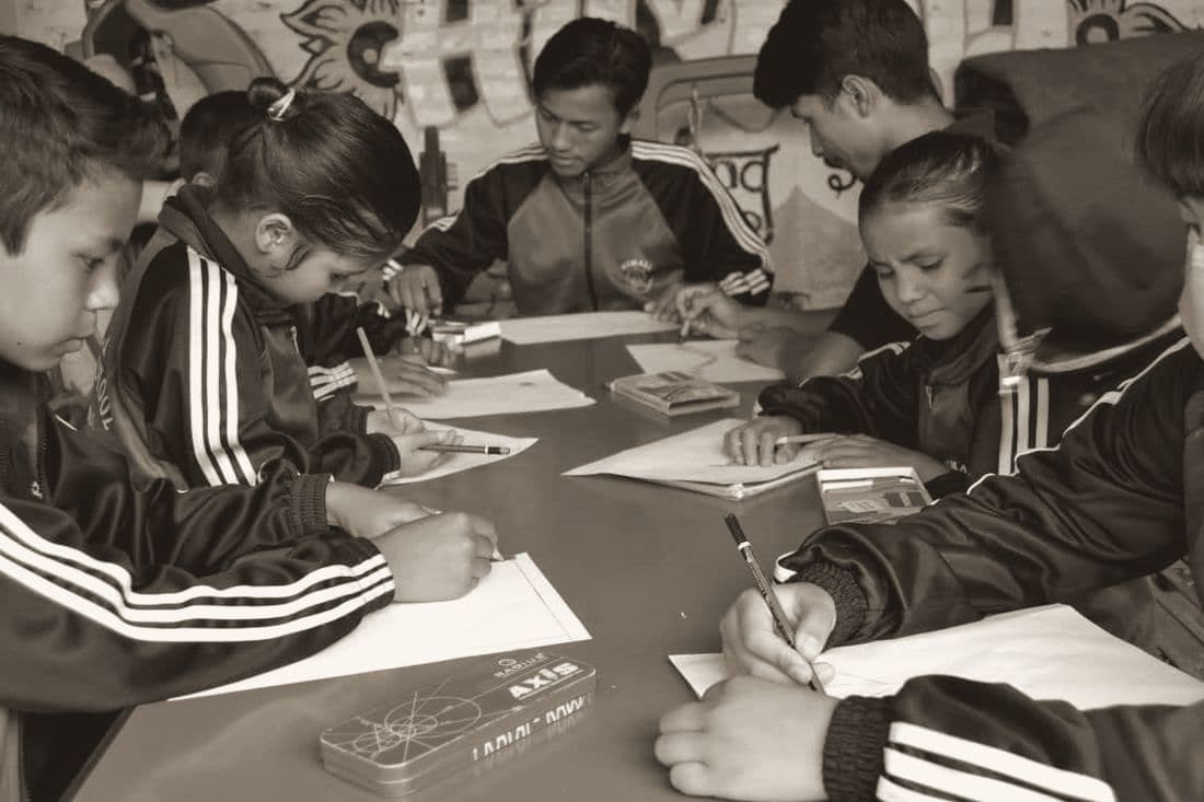 Children drawing together around a table