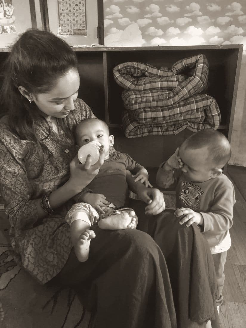 Pooja feeding a baby from a bottle
