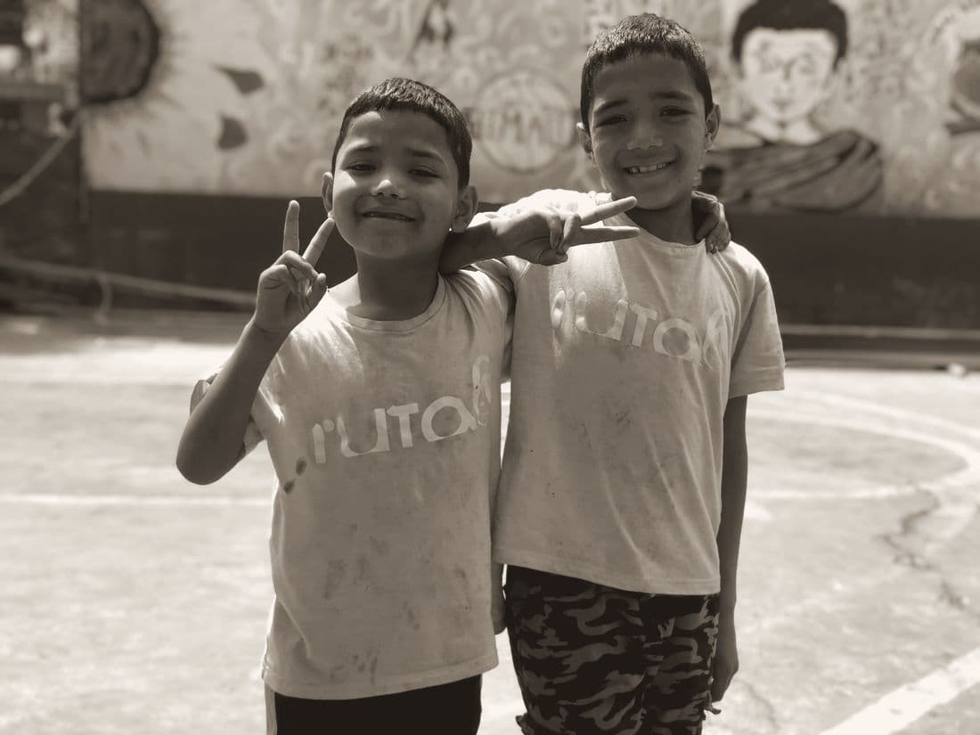Two boys in matching T-shirts making peace signs
